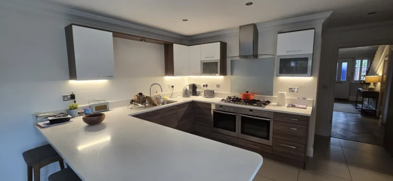 A kitchen with under cabinet lighting and downlights installed