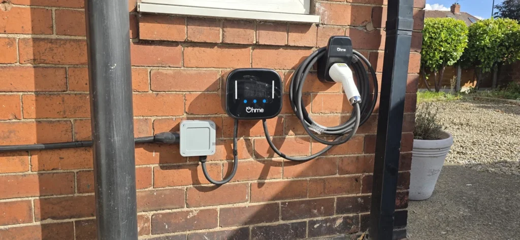 An Ohme EV charger installed on the brick wall of a house in York