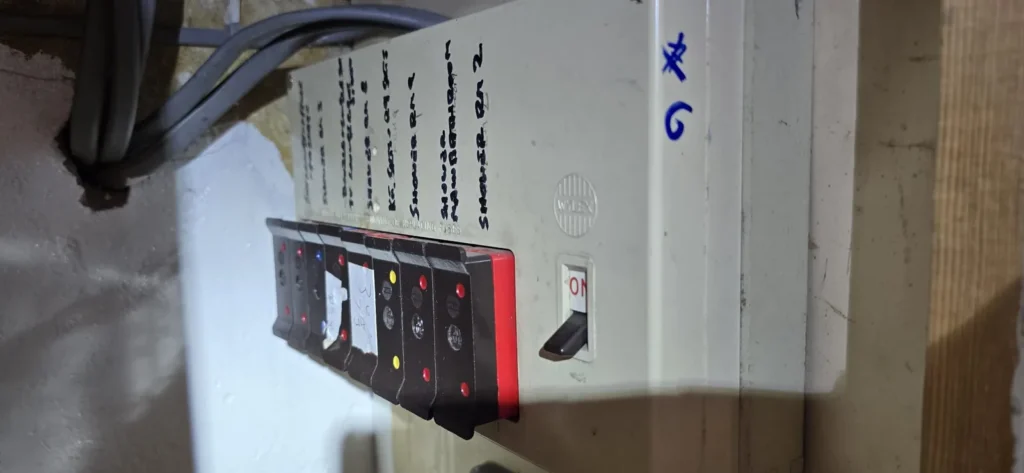 An older fuse board with handwritten circuit labels